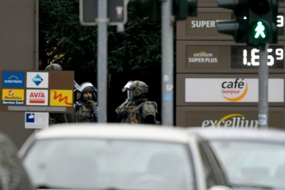 Schwer bewaffnete Polizisten stehen an einer Tankstelle im Bochumer Stadtteil Langendreer.