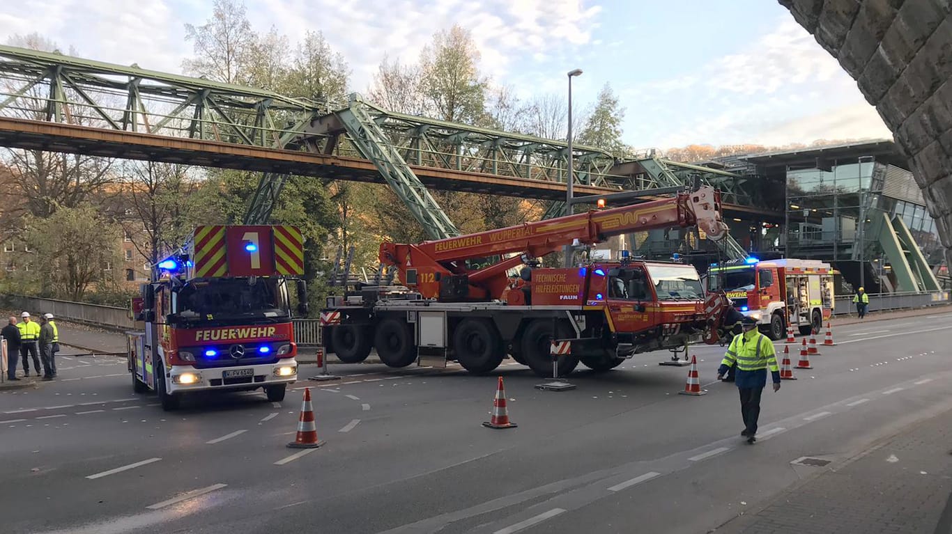 Die Wuppertaler Feuerwehr sichert den Gleisabschnitt der Schwebebahn: Die Stromschiene hatte sich gelöst und war auf einen Sportwagen gefallen.