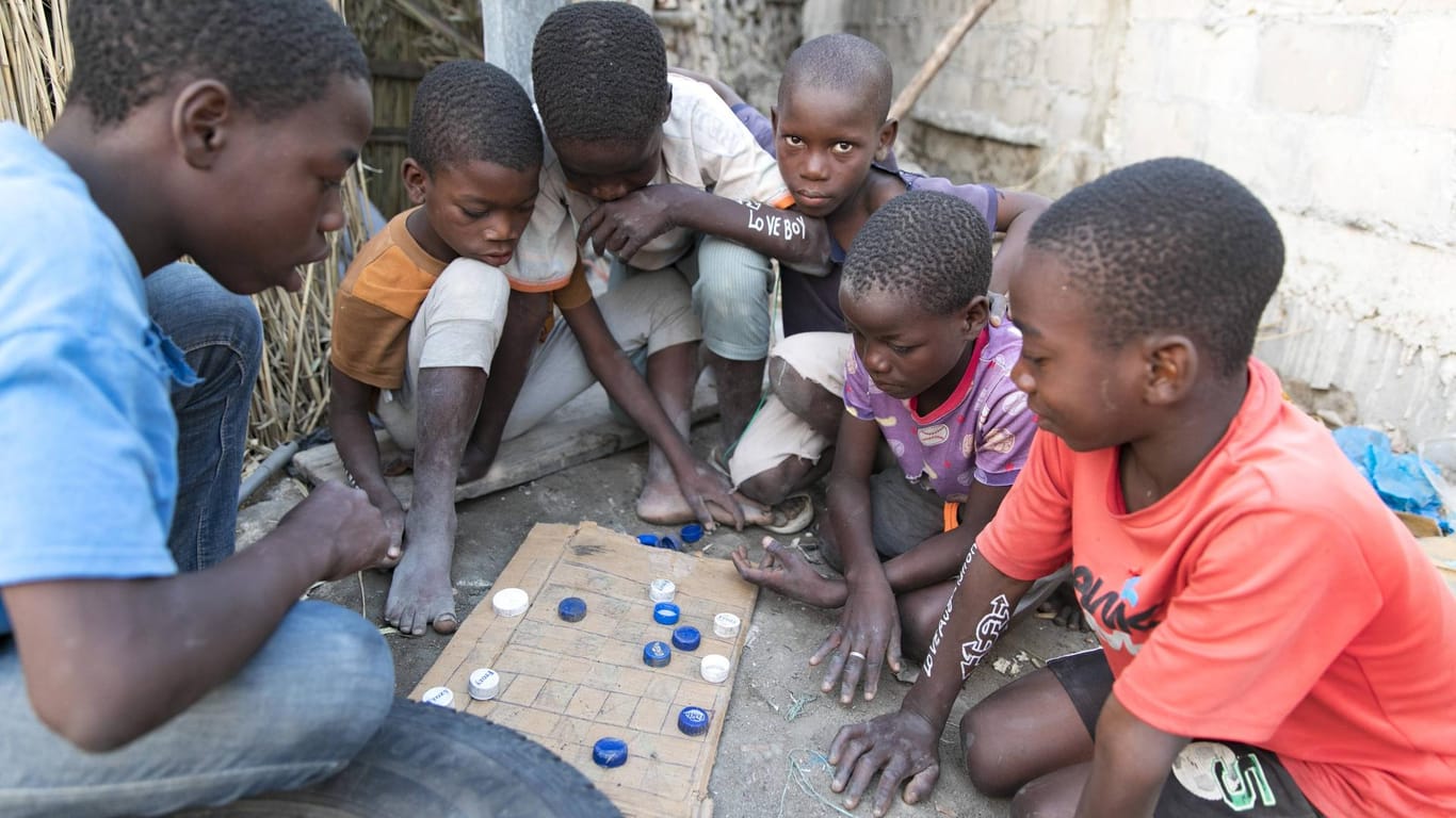 Kinder einer Siedlung in Mosambik spielen ein Brettspiel mit Plastikflaschenverschlüssen: Von den 15 Ländern mit der höchsten gesellschaftlichen Verwundbarkeit liegen 13 in Afrika.