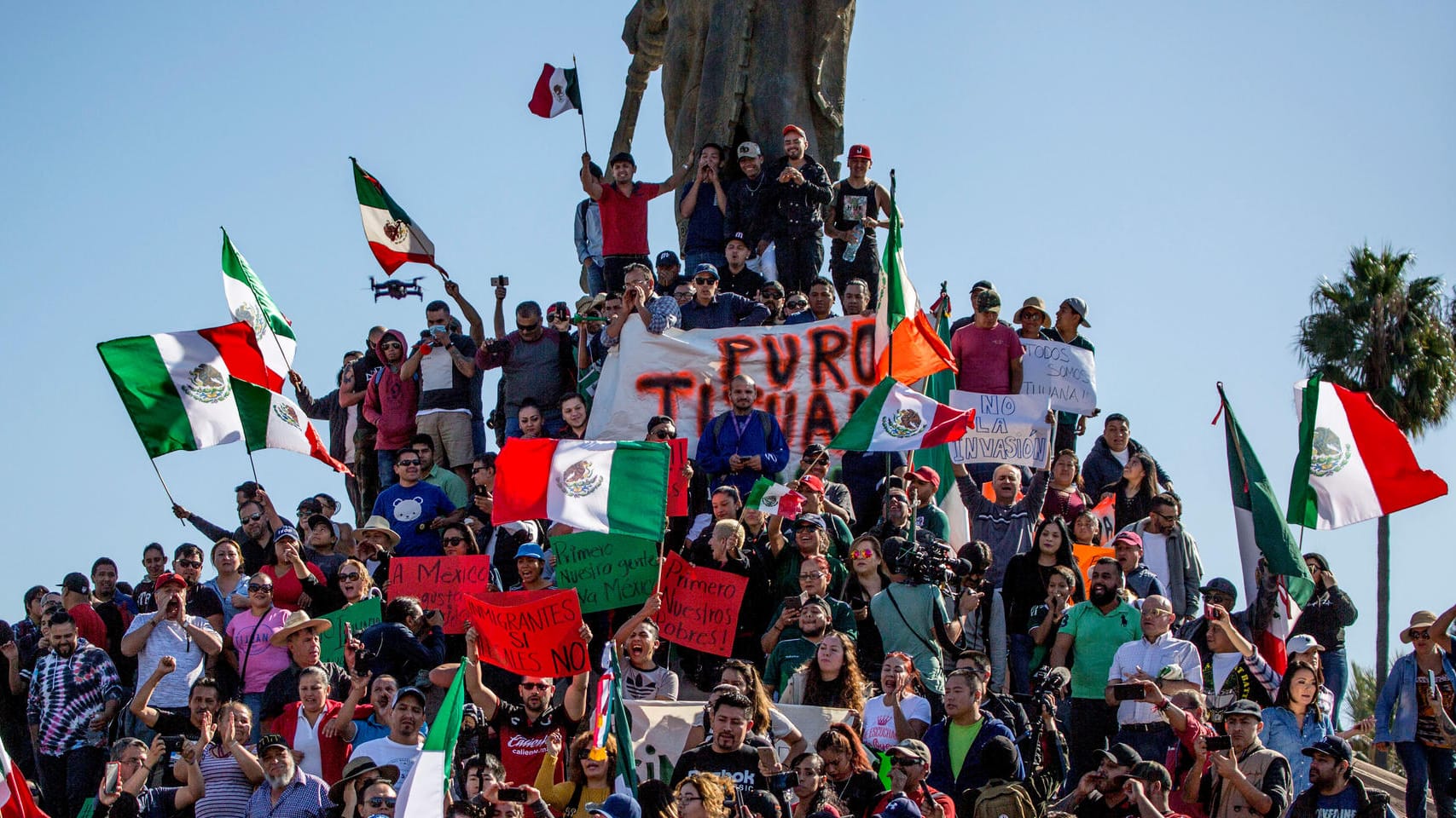 Anwohner der Stadt Tijuana schwenken bei einem Protest gegen die Ankunft von Migranten aus Mittelamerika mexikanische Flaggen: Nach der Ankunft Tausender Menschen aus Mittelamerika macht sich in Tijuana Unmut breit.