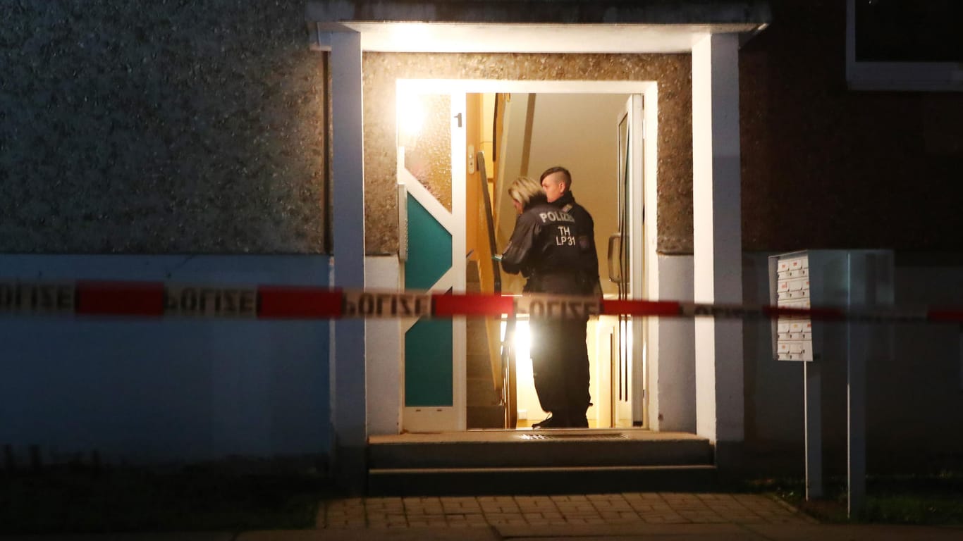 Polizeibeamte stehen im Eingang eines Wohnhauses in Jena: Hier wurden vier Leichen gefunden.