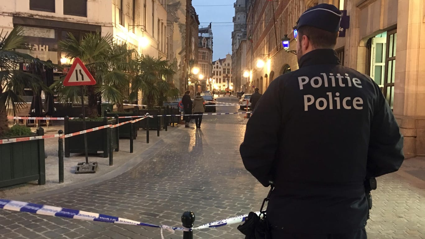 Ein Polizist steht hinter einem Polizeiband während der Ermittlungen am Ort der Messerattacke: Der Vorfall ereignete sich mitten im Zentrum von Brüssel.