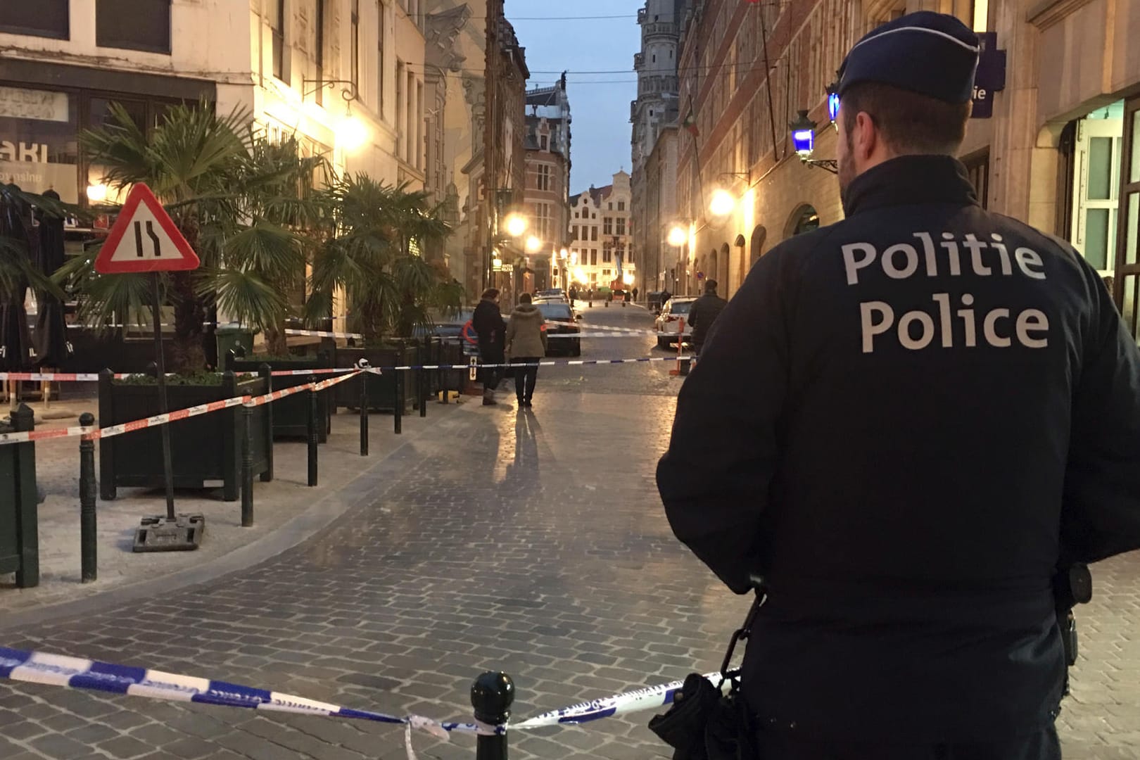 Ein Polizist steht hinter einem Polizeiband während der Ermittlungen am Ort der Messerattacke: Der Vorfall ereignete sich mitten im Zentrum von Brüssel.