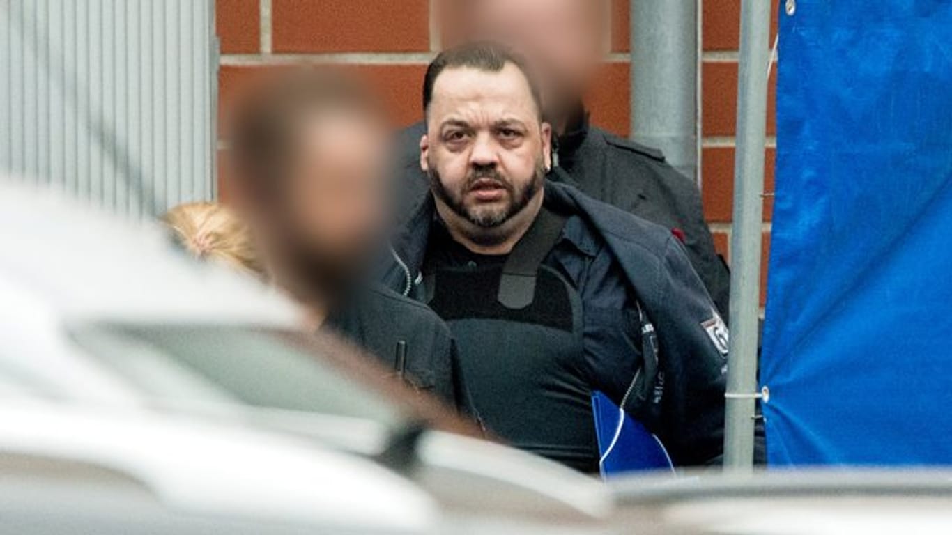 Der wegen vielfachen Mordes angeklagte Niels Högel wird von Justizbeamten zum Gefangenentransporter geführt.