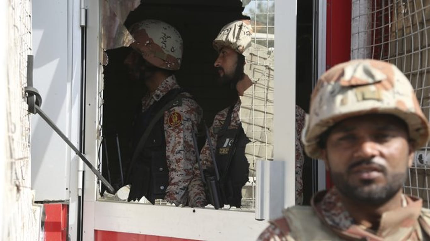 Ein pakistanischer Soldat vor einer zerstörten Scheibe des chinesischen Konsulats.