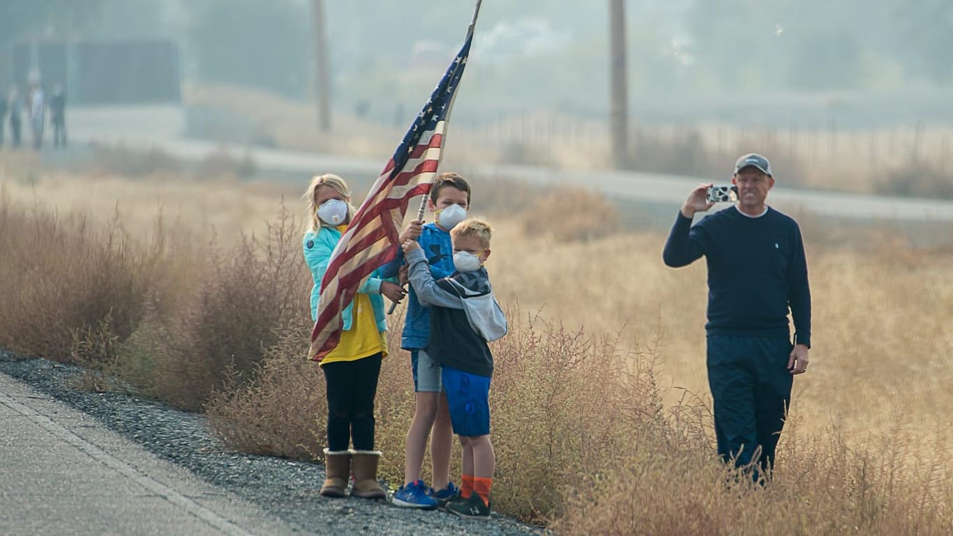 Chico, Kalifornien: Kinder mit Mundschutz stehen am Straßenrand, US-Präsident Trump vorbeifährt. Forscher deuten die Waldbrände dort als Folge des Klimawandels.