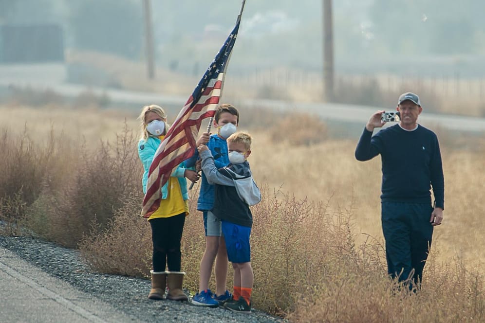 Chico, Kalifornien: Kinder mit Mundschutz stehen am Straßenrand, US-Präsident Trump vorbeifährt. Forscher deuten die Waldbrände dort als Folge des Klimawandels.