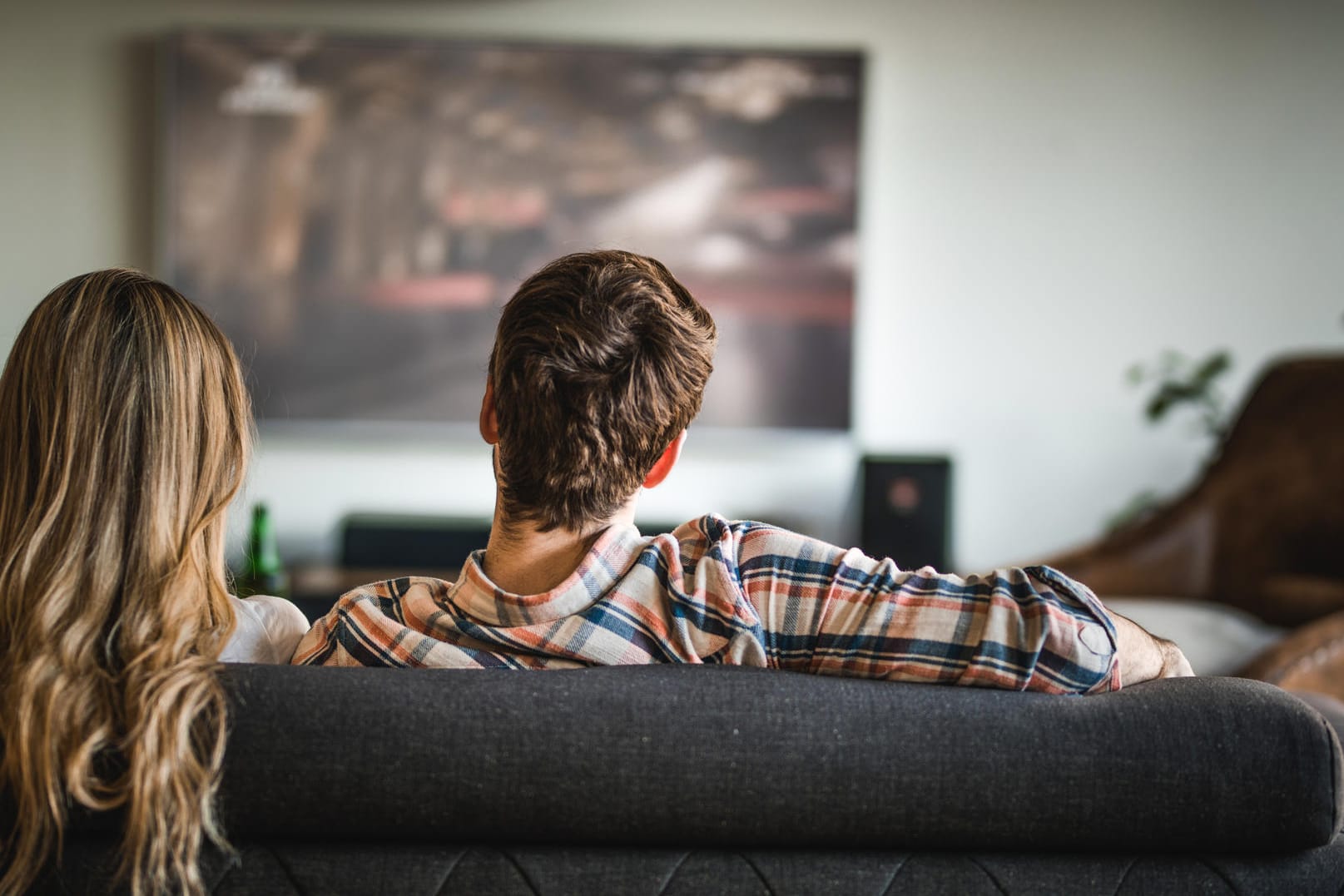 Ein Paar beim Fernsehen: Vodafone zieht mit der Telekom gleich und macht sein Fernsehangebot GigaTV zum eigenständigen Produkt für Kunden anderer Provider. Das Paket bietet 62 SD- und 40 HD-Sender und Mediatheken-Zugriff für 14,99 Euro pro Monat.
