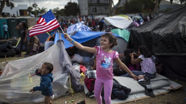 Ein Kind aus Honduras schwenkt eine amerikanische Flagge in Richtung eines Hubschraubers des US-Grenzschutzes.