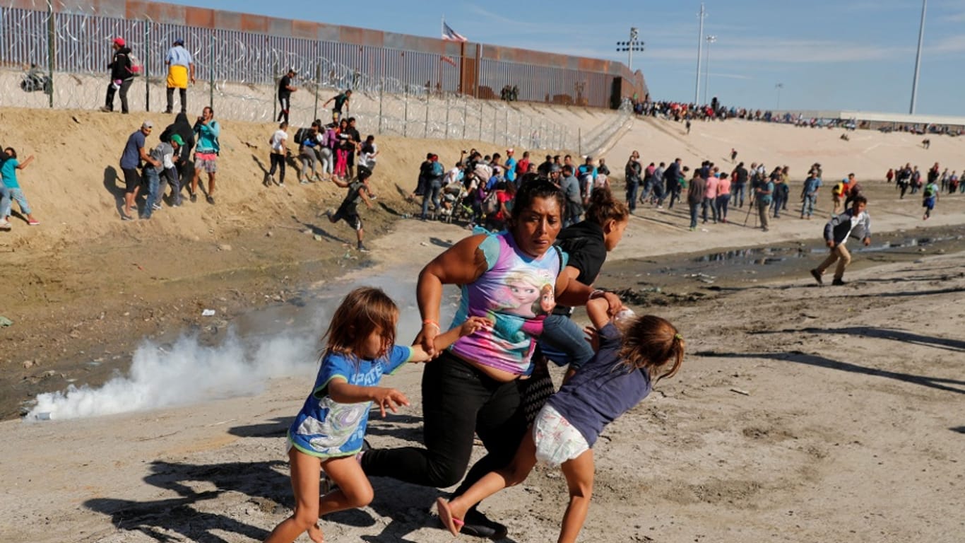 Eine Familie flieht vor dem Tränengas an der Grenze.