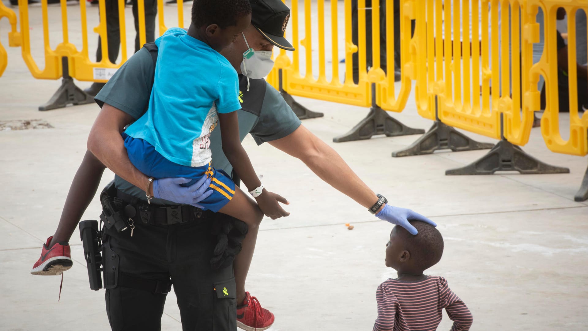 Ein Beamter der Guardia Civil trägt ein Flüchtlingskind (Archivbild)