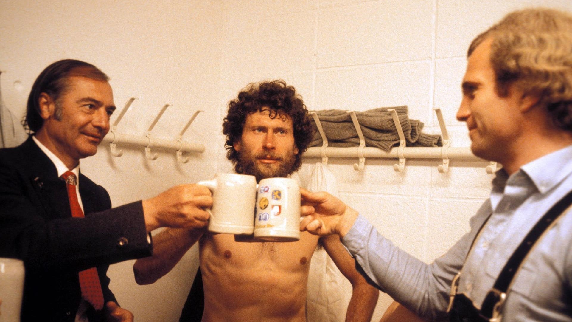 Weggefährten: Trainer Pal Csernai (v. l.), Paul Breitner und Manager Uli Hoeneß stoßen in der Umkleidekabine auf den Gewinn der deutschen Meisterschaft 1980 an.