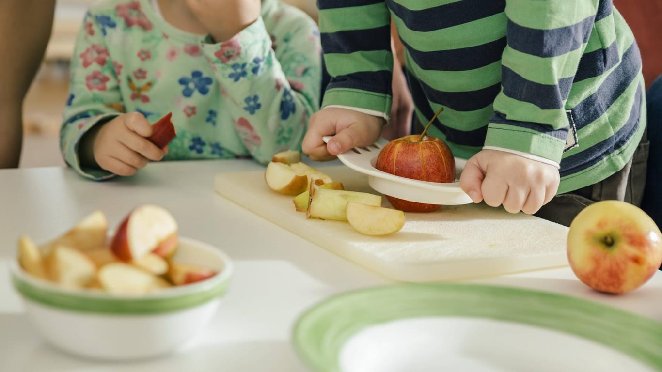 Kinder essen einen Apfel: Ein Mädchen ist bei einer Essenspause im Kindergarten erstickt.