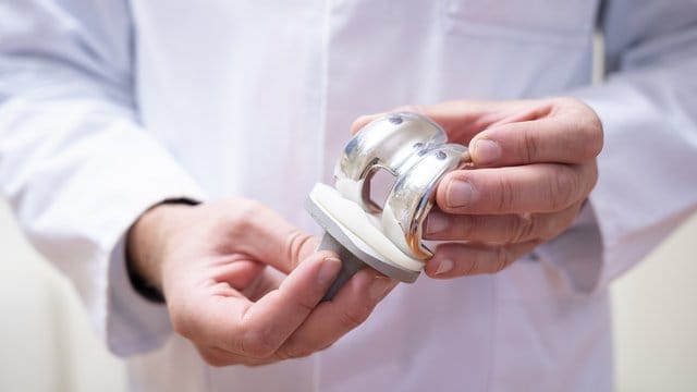 Ein Arzt hält im Helios Klinikum Berlin-Buch eine Knieprothese in den Händen. Ein Arzt hält im Helios Klinikum Berlin-Buch eine Knieprothese in den Händen.