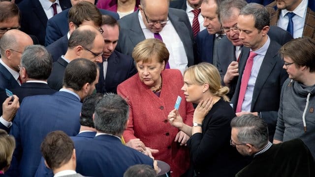 Bundeskanzlerin Angela Merkel (M) gibt bei der namentlichen Abstimmung über den UN-Migrationspakt ihre Stimmkarte ab. Bundeskanzlerin Angela Merkel (M) gibt bei der namentlichen Abstimmung über den UN-Migrationspakt ihre Stimmkarte ab.