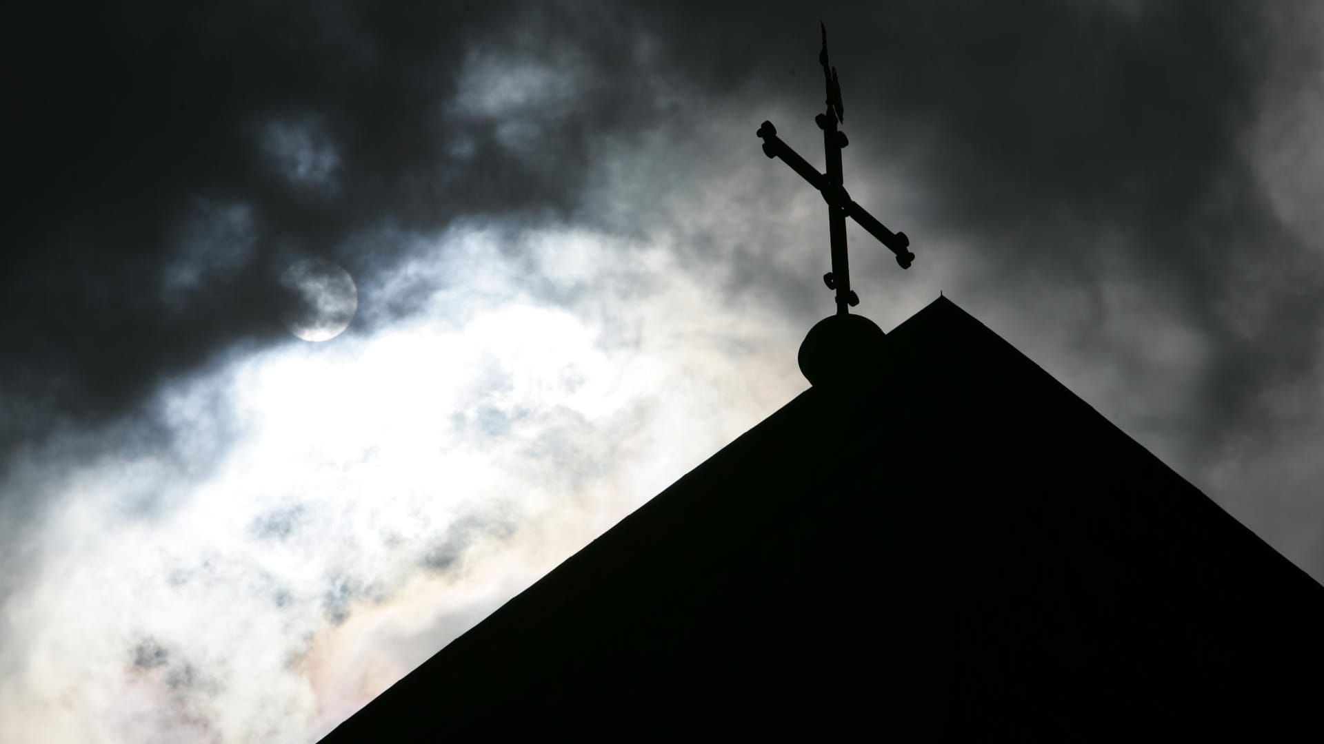Dunkle Wolken über einer Kirchturmspitze (Symbolbild): Die Staatsanwaltschaft wirft einem 65 Jahre alten Diakon Vergewaltigung einer 15-Jährigen vor. Dunkle Wolken über einer Kirchturmspitze (Symbolbild): Die Staatsanwaltschaft wirft einem 65 Jahre alten Diakon Vergewaltigung einer 15-Jährigen vor.