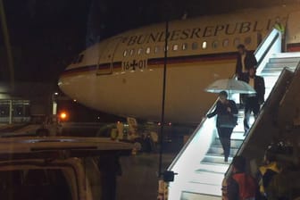 Angela Merkel verlässt mit einem Regenschirm in der Hand auf dem Rollfeld des Flughafens in Köln den Kanzler-Airbus "Konrad Adenauer": Wegen eines technischen Defekts am Flugzeug hat Merkel ihren Flug von Berlin zum G20-Gipfel in Buenos Aires am Donnerstagabend unterbrechen müssen.
