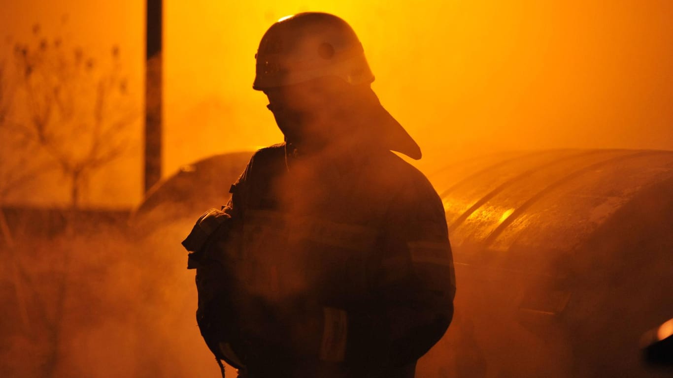 Feuerwehrmann im Schein eines brennenden Müllcontainers: Angriffe auf Feuerwehrleute gibt es vor allem in Berlin und NRW. (Archivfoto)