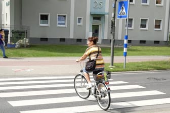 Eine Radfahrerin überquert einen Zebrastreifen: An einem Zebrastreifen in Paderborn machte ein Linienbus eine Vollbremsung, um nicht mit einem Radfahrer zu kollidieren.