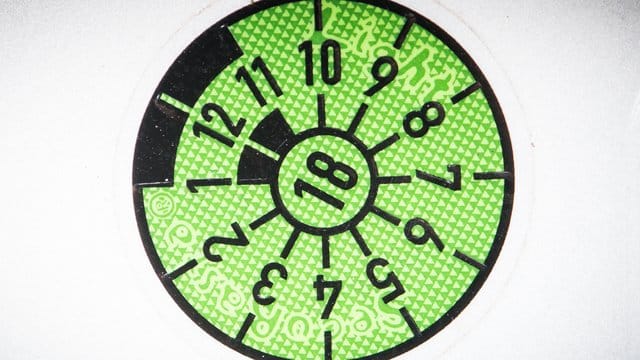 Die schwarze Markierung der HU-Plakette zeigt wie ein Stundenzeiger eines Zifferblatts den fälligen Monat des Prüftermins an - hier auf der "10-Uhr"-Position der Oktober. Die schwarze Markierung der HU-Plakette zeigt wie ein Stundenzeiger eines Zifferblatts den fälligen Monat des Prüftermins an - hier auf der "10-Uhr"-Position der Oktober.