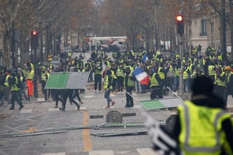 Die "Gelbwesten" beim Demonstrieren: Identitäts- und Sicherheitskontrollen am Champs-Élysées sollen heftigen Ausschreitungen auf dem Boulevard vorbeugen.