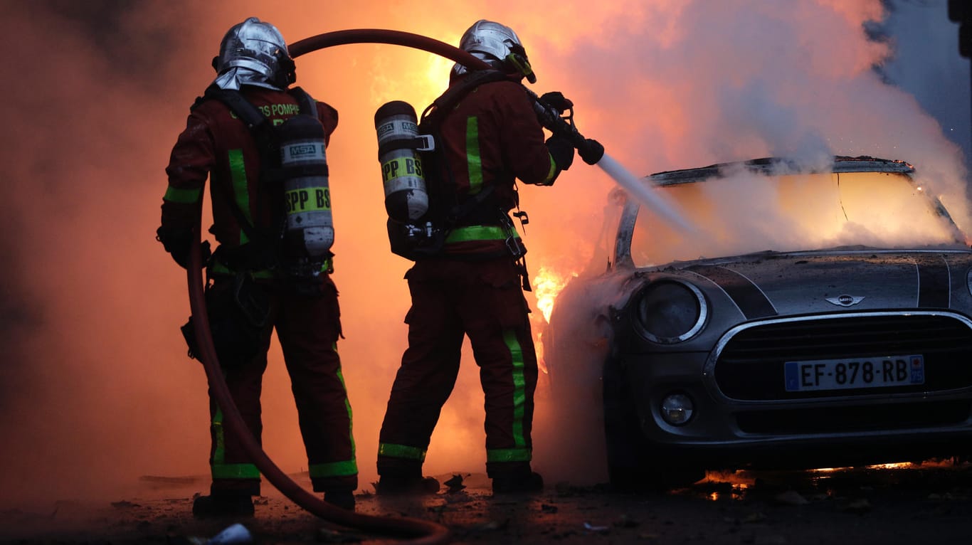 Paris: Feuerwehrleute löschen bei einem Protest der sogenannten "Gelbwesten" in der Nähe der Champs-Elysees ein brennendes Auto.