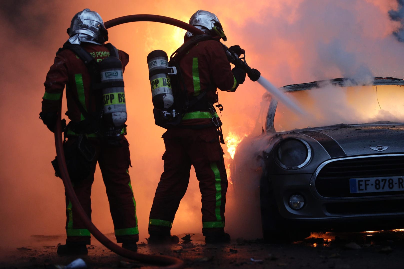 Paris: Feuerwehrleute löschen bei einem Protest der sogenannten "Gelbwesten" in der Nähe der Champs-Elysees ein brennendes Auto.
