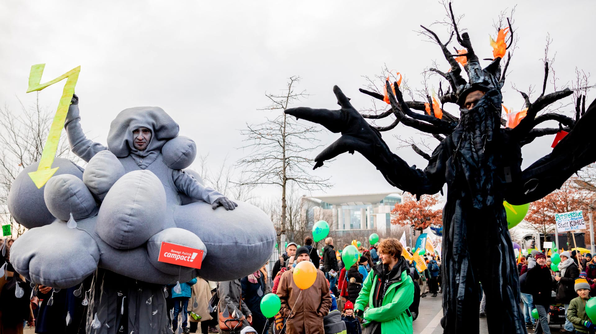 Als eine Gewitterwolke und als brennender Baum verkleidete Teilnehmer nahmen an der Demonstration in Berlin teil.