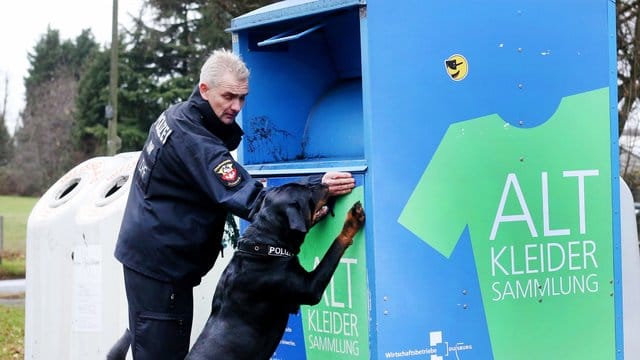 Polizeispürhund "Amigo" und sein Hundeführer suchen nach Spuren an einem Altkleidercontainer. Polizeispürhund "Amigo" und sein Hundeführer suchen nach Spuren an einem Altkleidercontainer.