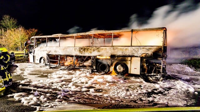 Der ausgebrannte Reisebus steht auf der Autobahn A3.