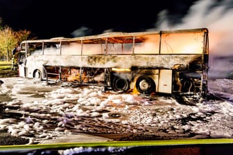 Ein ausgebrannter Reisebus steht auf der Autobahn A3: Die Polizei schätzt den Schaden auf rund 200.000 Euro.