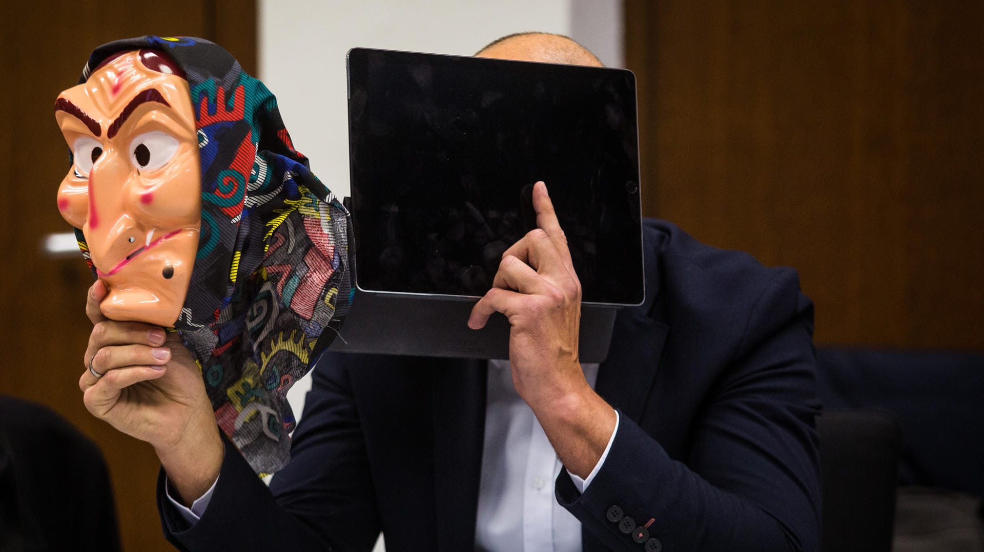 Ein Angeklagter hält eine Hexenmaske in seiner Hand: Der Mann muss sich wegen fahrlässiger Körperverletzung vor Gericht verantworten. Ein Angeklagter hält eine Hexenmaske in seiner Hand: Der Mann muss sich wegen fahrlässiger Körperverletzung vor Gericht verantworten.