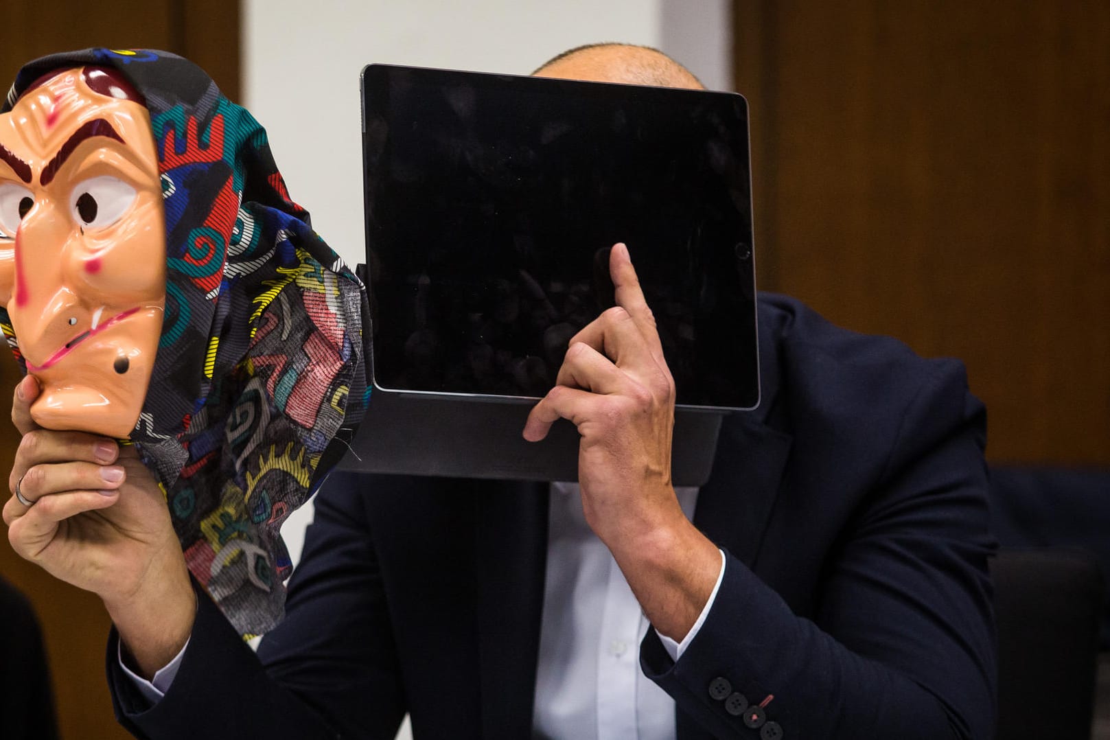 Ein Angeklagter hält eine Hexenmaske in seiner Hand: Der Mann muss sich wegen fahrlässiger Körperverletzung vor Gericht verantworten.