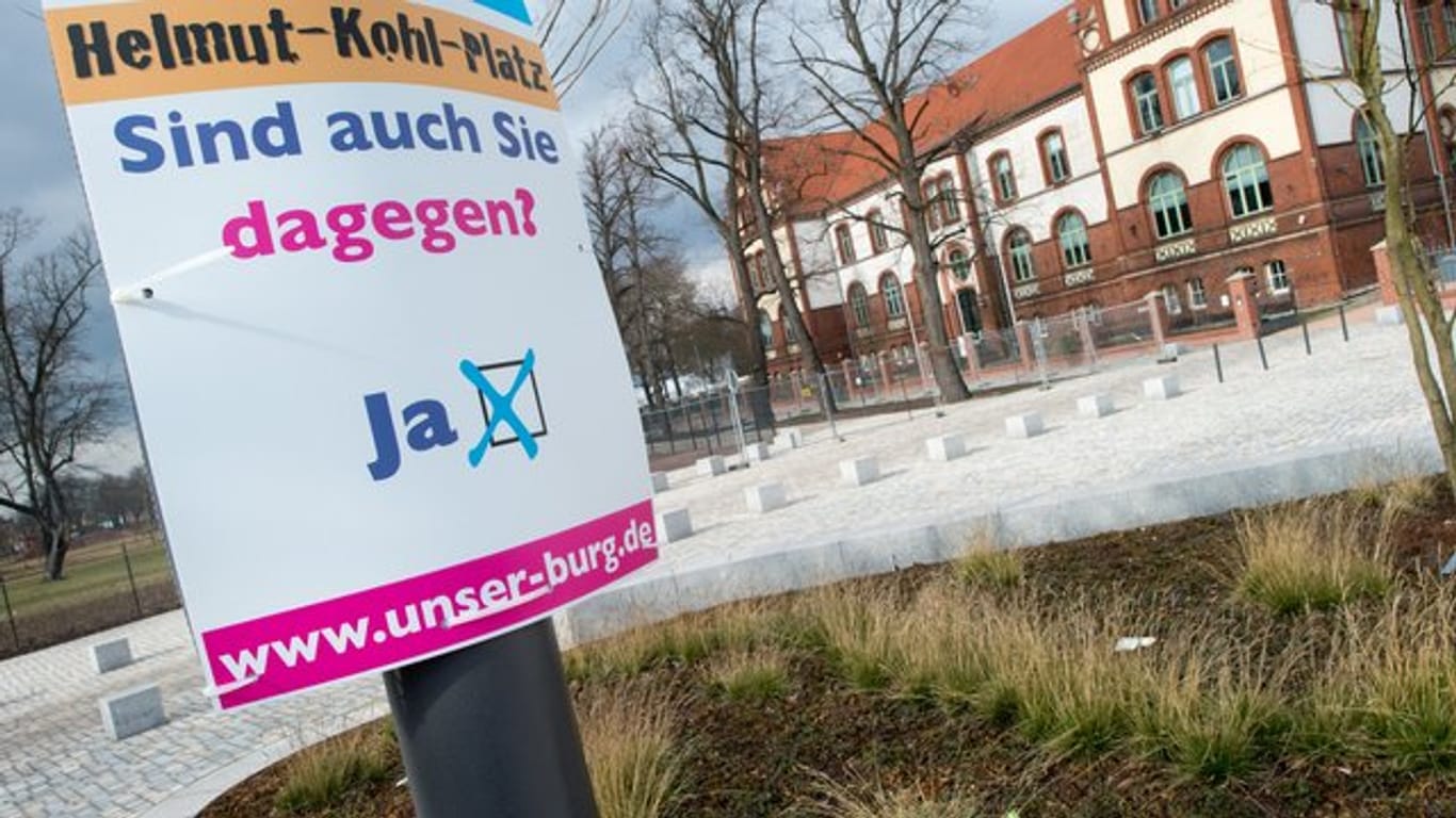 "Helmut-Kohl-Platz" und "Sind Sie auch dagegen" steht auf einem Schild der Bürgerinitiative "Unser Burg".
