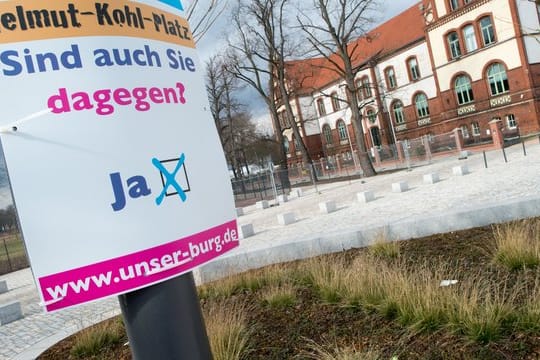 "Helmut-Kohl-Platz" und "Sind Sie auch dagegen" steht auf einem Schild der Bürgerinitiative "Unser Burg".