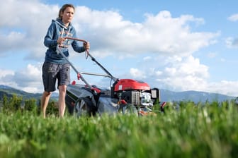 Frau mäht Rasen: Der Gartengerätehersteller Gardena ruft Rasenmäher wegen möglicher Feuergefahr zurück. (Symbolbild)