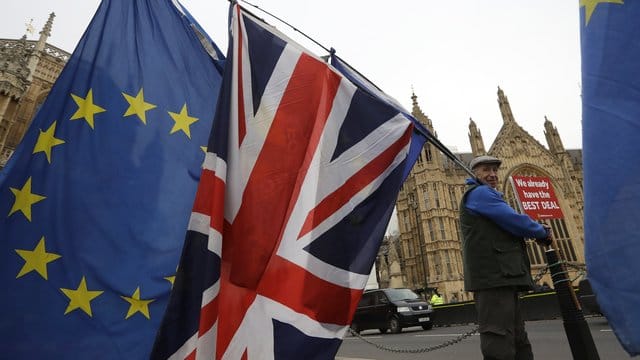 Ein Demonstrant protestiert mit einer EU-Fahne und der Nationalflagge des Vereinigten Königreichs vor dem Parlament in London. Ein Demonstrant protestiert mit einer EU-Fahne und der Nationalflagge des Vereinigten Königreichs vor dem Parlament in London.