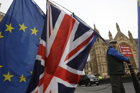 Ein Demonstrant protestiert mit einer EU-Fahne und der Nationalflagge des Vereinigten Königreichs vor dem Parlament in London.