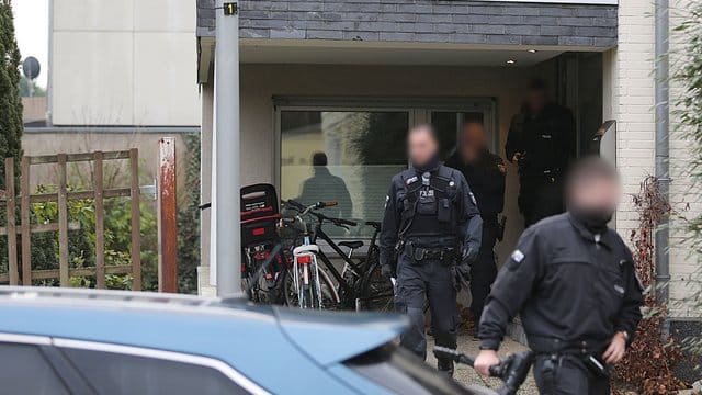 Polizisten verlassen das Wohnhaus eines Italieners in Pulheim: Bei den großangelegten Razzien waren 440 Beamte beteiligt.