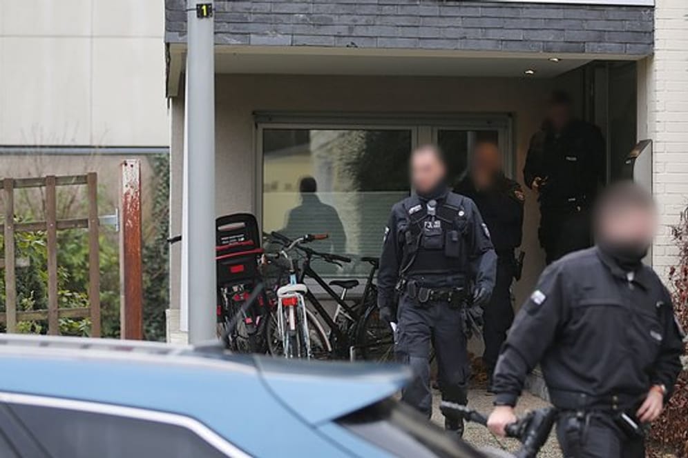 Polizisten verlassen das Wohnhaus eines Italieners in Pulheim: Bei den großangelegten Razzien waren 440 Beamte beteiligt.