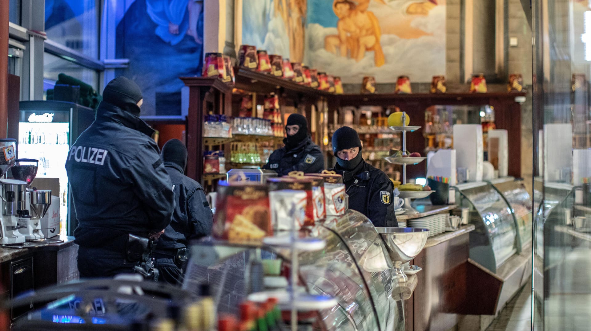 Polizisten in einem Eiscafé in Duisburg: Die Sicherheitsbehörden sind in einer internationalen Aktion gegen die italienische Mafia 'Ndrangheta vorgegangen.