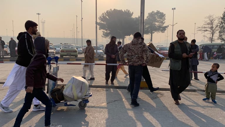 Männer am Flughafen in Kabul: Aus Deutschland abgeschobene afghanische Asylbewerber verlassen nach ihrer Ankunft den Flughafen.