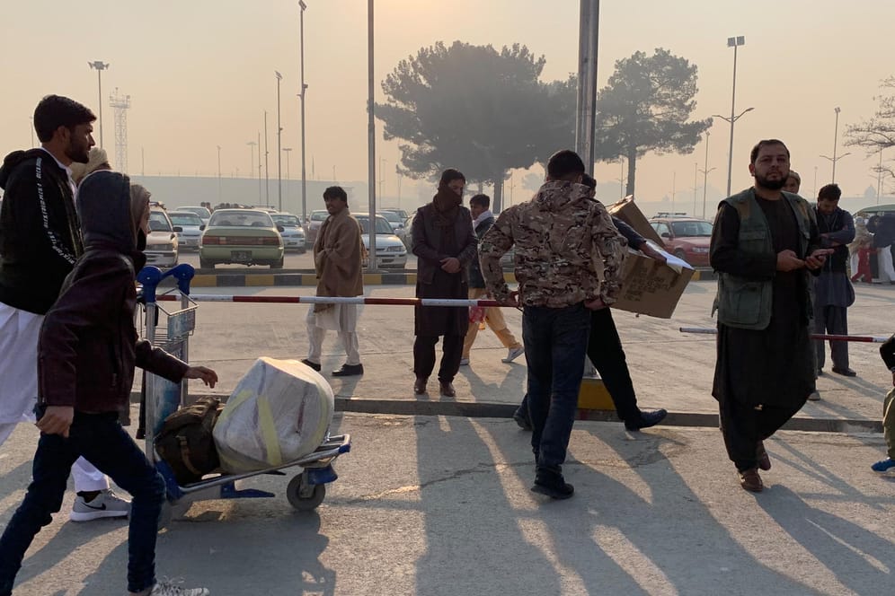 Männer am Flughafen in Kabul: Aus Deutschland abgeschobene afghanische Asylbewerber verlassen nach ihrer Ankunft den Flughafen.