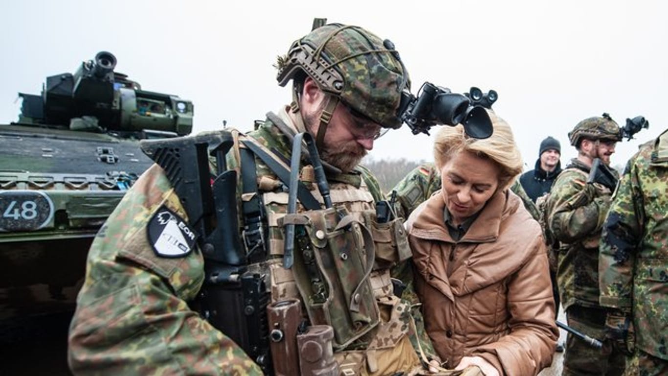 Verteidigungsministerin Ursula von der Leyen lässt sich von einem Soldaten ein Navigationsgerät erklären.
