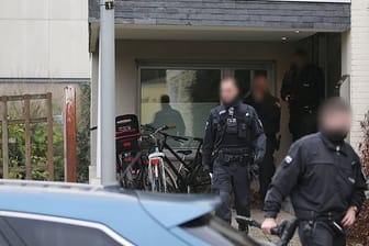 Polizisten verlassen das Wohnhaus eines Italieners in Pulheim: Bei den großangelegten Razzien waren 440 Beamte beteiligt.
