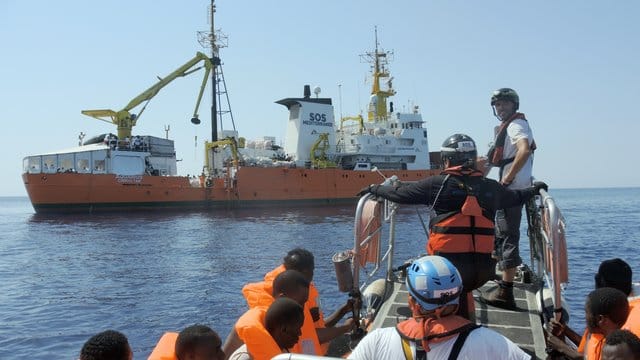 Gerettete Menschen werden an Bord der "Aquarius" gebracht.