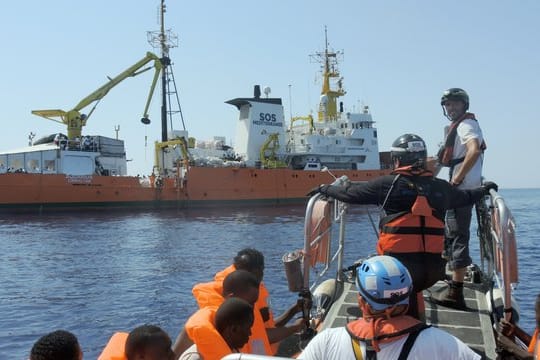 Gerettete Menschen werden an Bord der "Aquarius" gebracht.