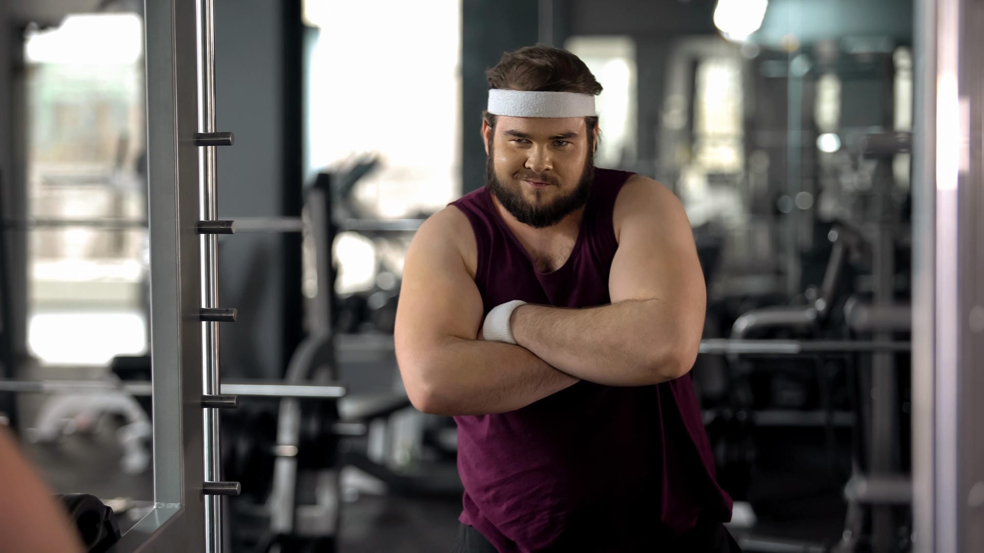 Fat man with folded hands looking at mirror, satisfied with weight loss results