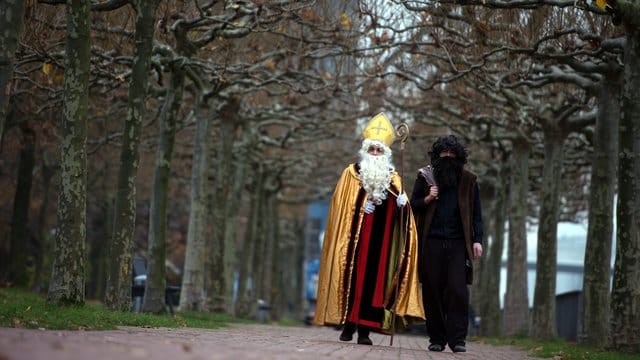 Nikolaus (l) und Knecht Ruprecht am Rheinufer in Düsseldorf.
