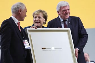 Ein Taktstock für die Taktgeberin: Angela Merkel mit CDU-Bundesgeschäftsführer Klaus Schüler und Hessens Ministerpräsident Volker Bouffier.